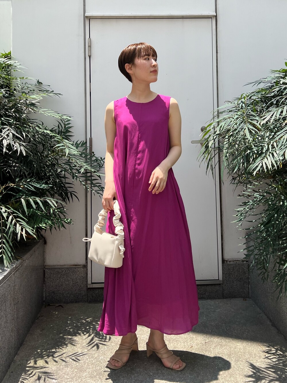 ベージュ系のサンダル、ホワイト系のハンドバッグ、パープル系のワンピースを着用したレディースの夏コーディネートの5枚目の写真