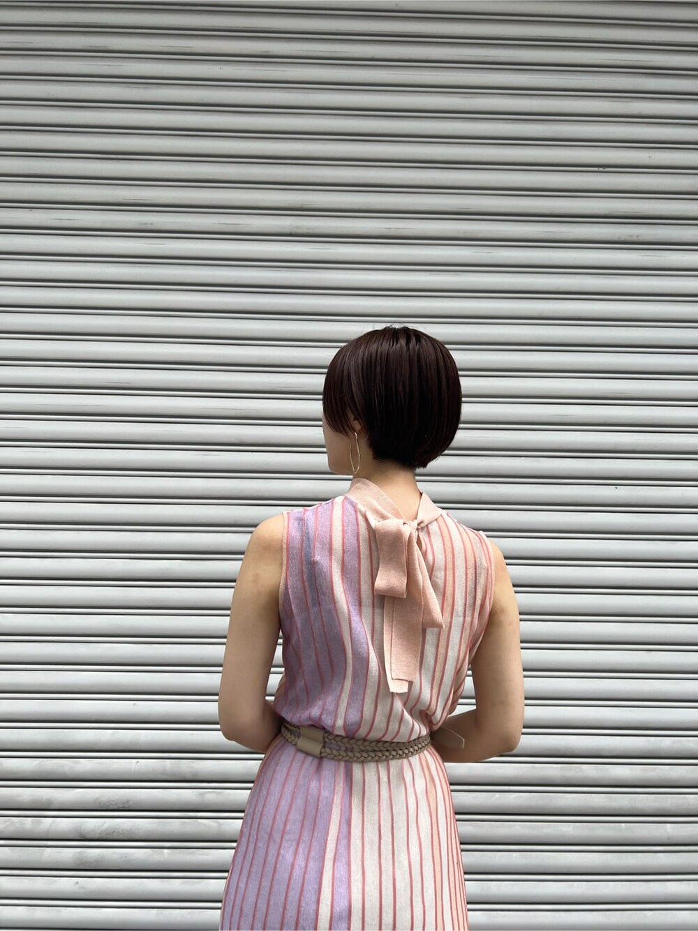 オレンジ系のワンピース、その他のパンプス、ホワイト系のカーディガン/ボレロを着用したレディースの春コーディネートの7枚目の写真