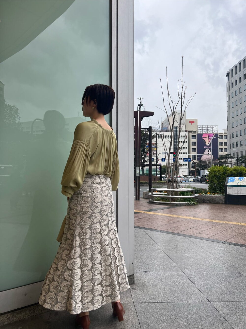 ホワイト系のハンドバッグ、ホワイト系のパンプス、グリーン系のシャツ/ブラウスを着用したレディースの春コーディネートの2枚目の写真