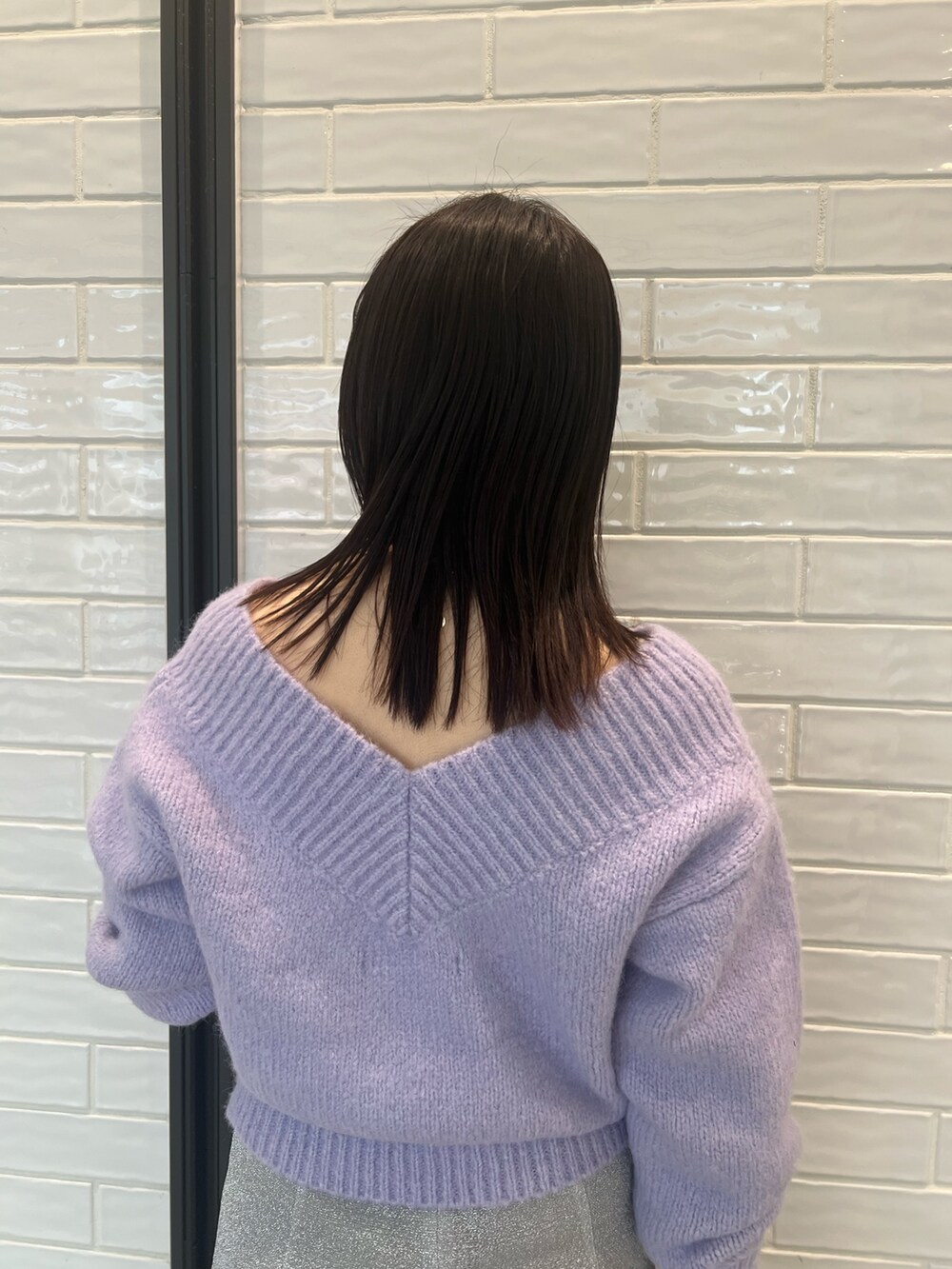 パープル系のニット/セーター、シルバー系のスカートを着用したレディースの冬コーディネートの5枚目の写真