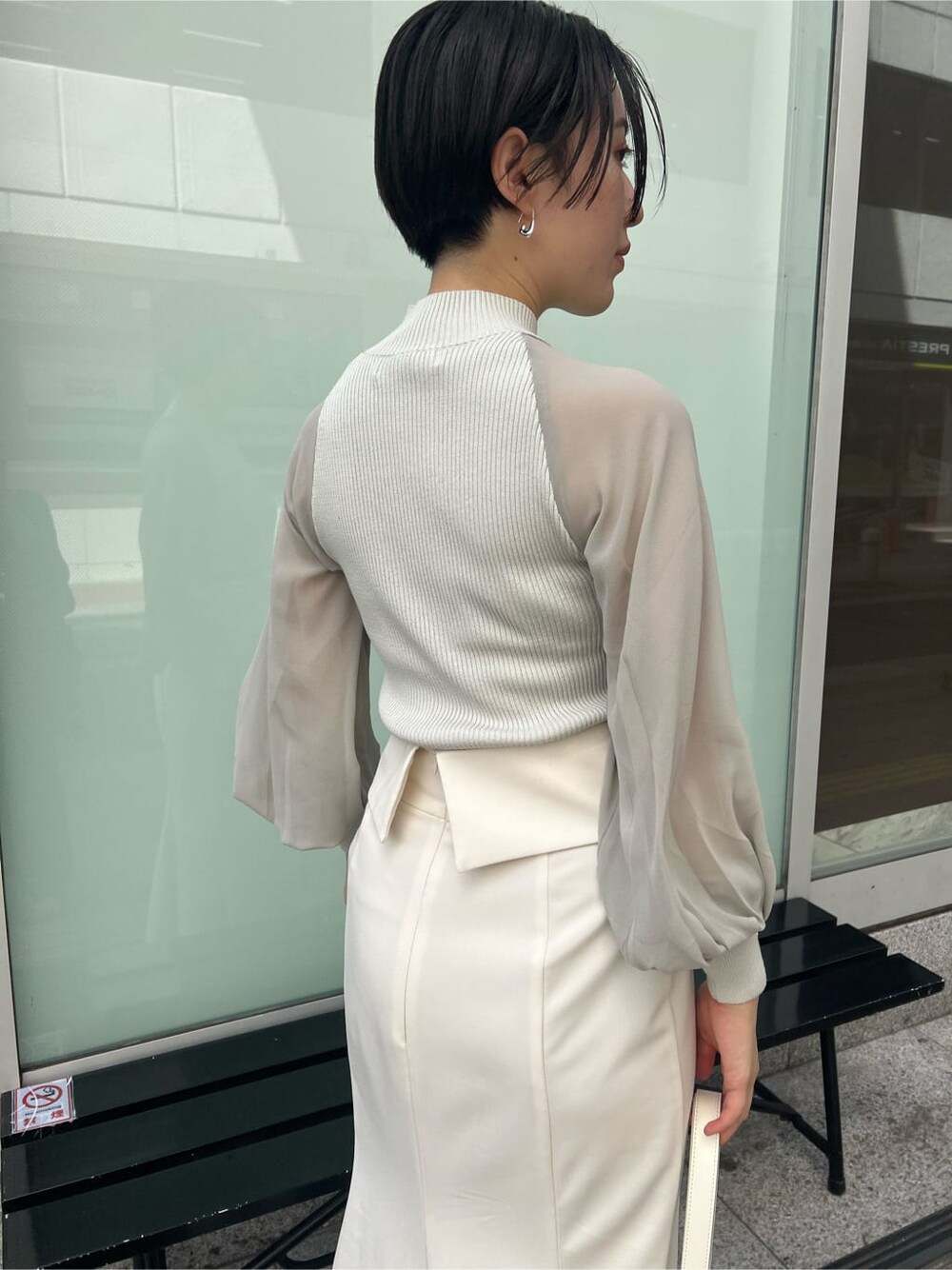 ベージュ系のブーツ、ブラック系のその他トップス、ホワイト系のスカートを着用したレディースの夏コーディネートの6枚目の写真