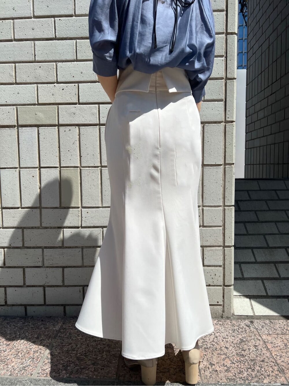 ホワイト系のスカート、その他のパンプス、ブルー系のシャツ/ブラウスを着用したレディースの春コーディネートの5枚目の写真