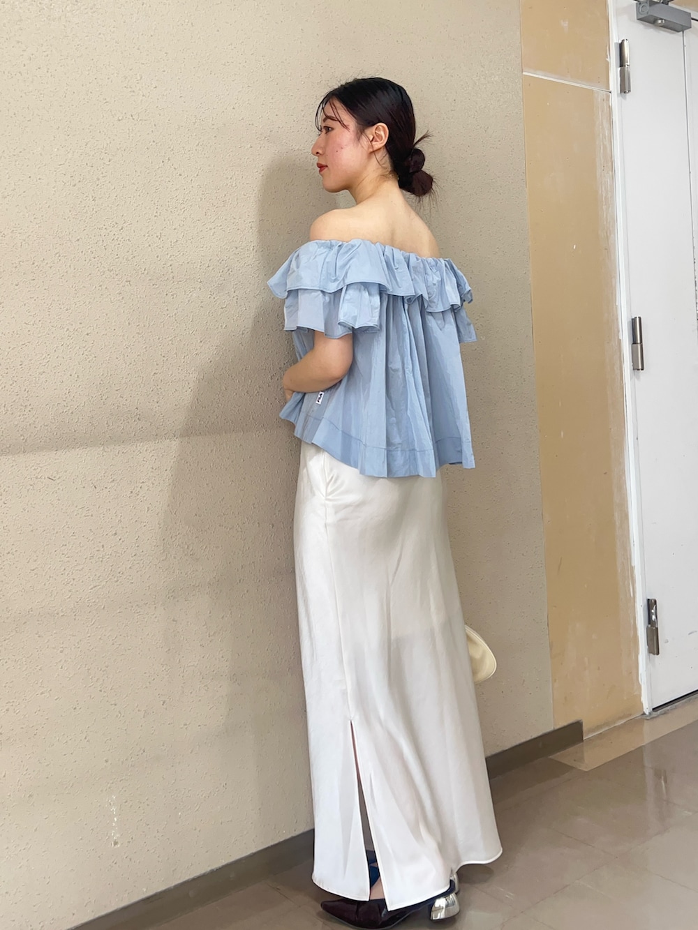 ブルー系のシャツ/ブラウス、ホワイト系のスカート、ブラック系のパンプスを着用したレディースの春コーディネートの2枚目の写真