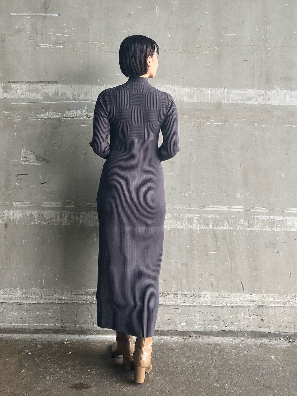 ブラック系のハンドバッグ、ベージュ系のブーツ、ホワイト系のカーディガン/ボレロを着用したレディースの冬コーディネートの5枚目の写真