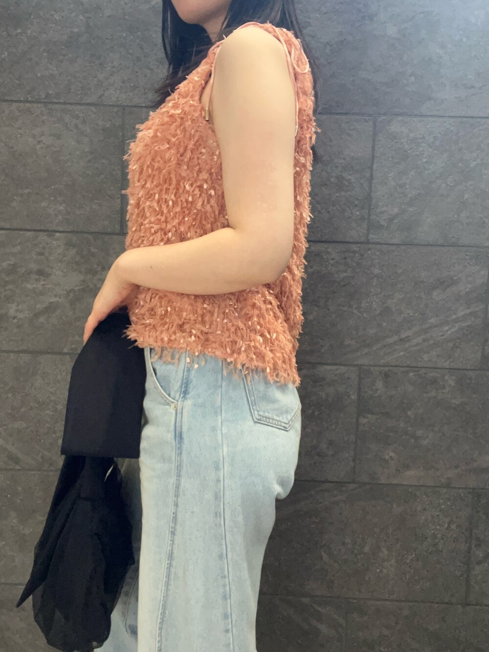 オレンジ系のTシャツ/カットソー、ホワイト系のサンダル、ブルー系のデニムパンツを着用したレディースの夏コーディネートの6枚目の写真