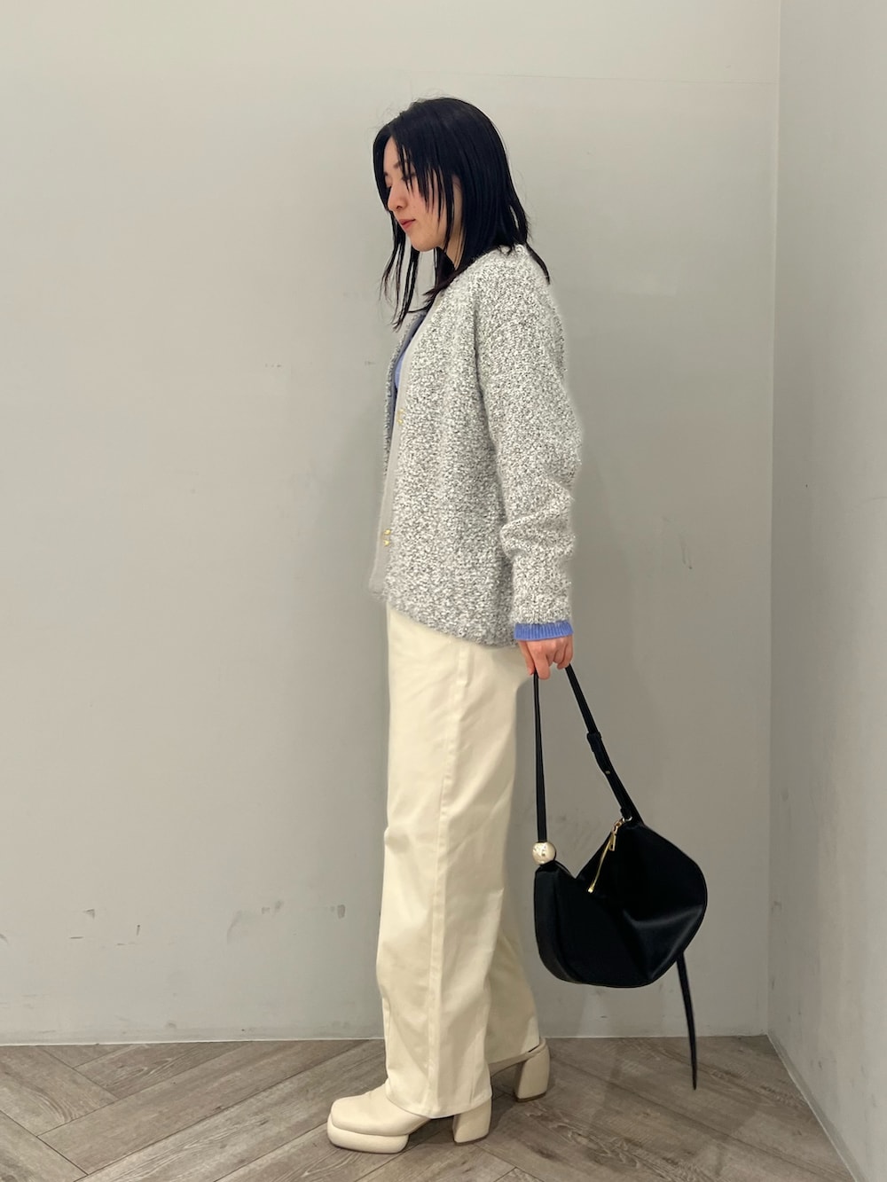 グレー系のカーディガン/ボレロ、ブルー系のニット/セーター、ホワイト系のその他パンツを着用したレディースの春コーディネートの2枚目の写真