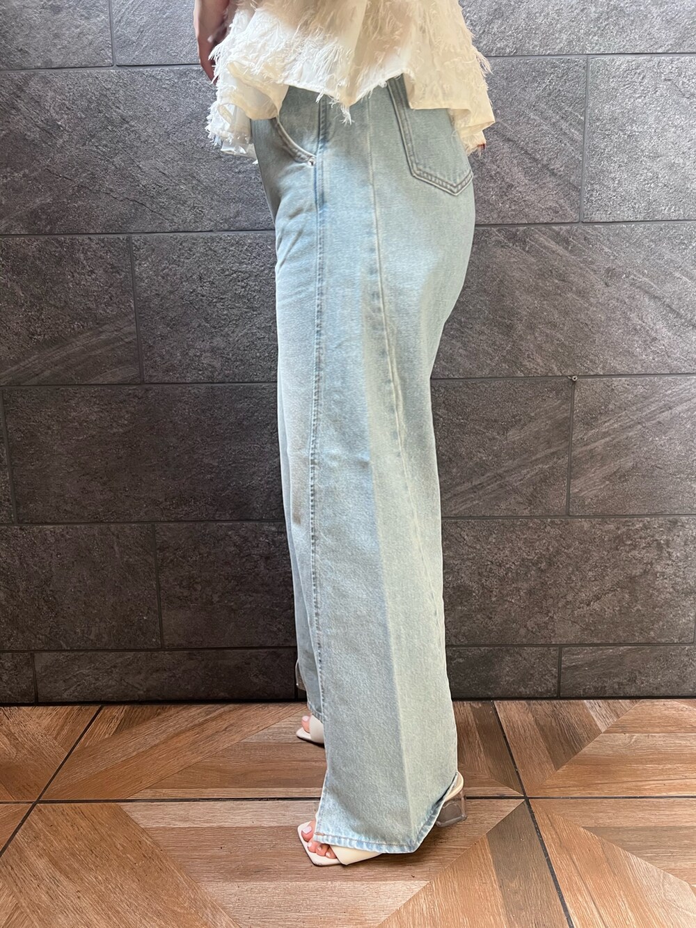 ホワイト系のサンダル、ホワイト系のキャミソール、ブルー系のデニムパンツを着用したレディースの夏コーディネートの6枚目の写真