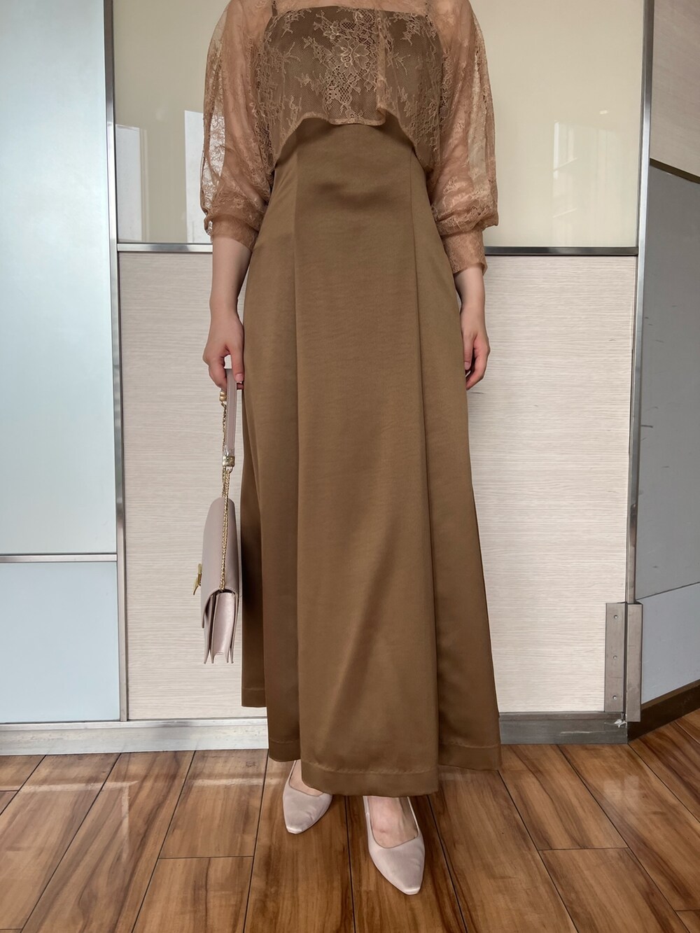 ベージュ系のクラッチバッグ、ブラウン系のドレス、ベージュ系のパンプスを着用したレディースの夏コーディネートの7枚目の写真