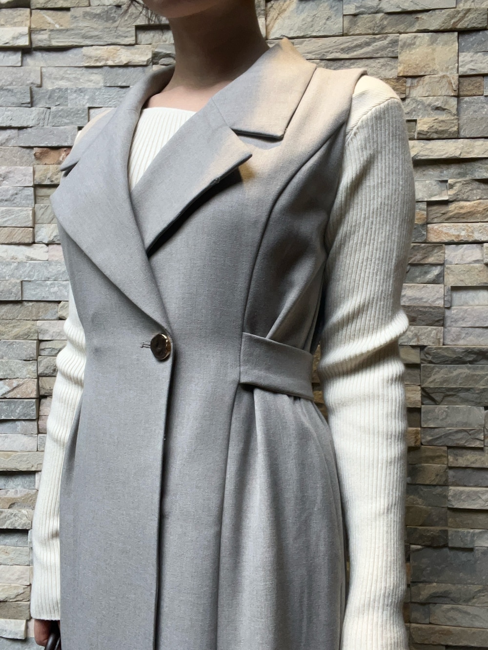 ブラウン系のパンプス、グレー系のワンピース、ホワイト系のニット/セーターを着用したレディースの秋コーディネートの4枚目の写真