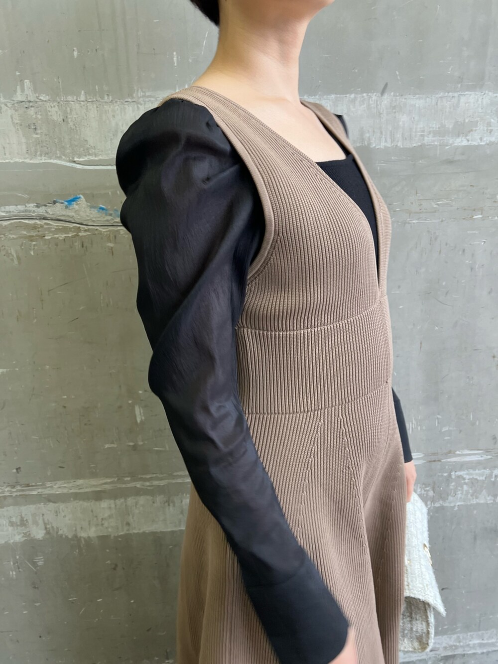 ブラック系のニット/セーター、ホワイト系のショルダーバッグ、ベージュ系のブーツを着用したレディースの冬コーディネートの4枚目の写真