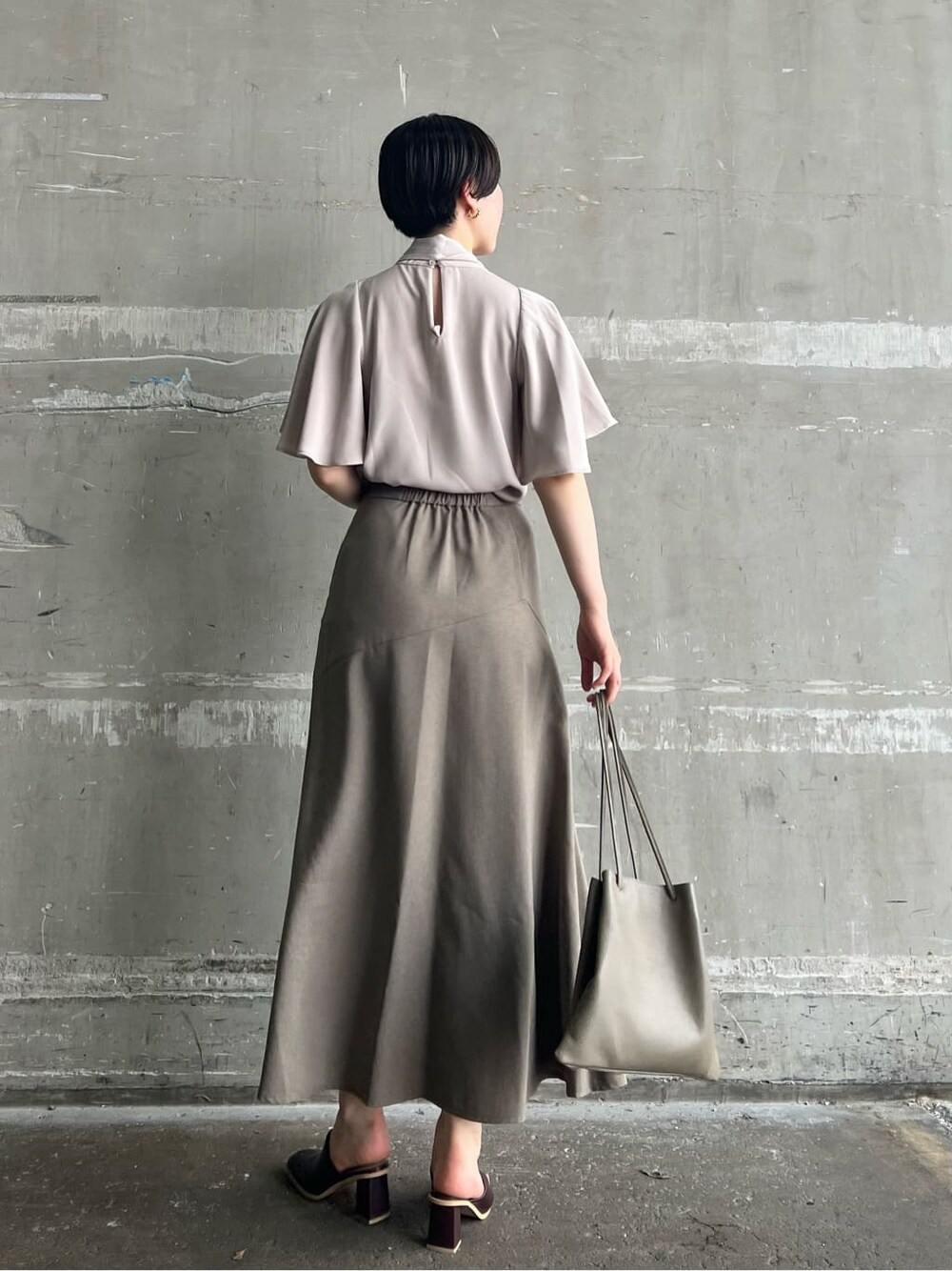 ベージュ系のハンドバッグ、レッド系のサンダル、ベージュ系のスカートを着用したレディースの夏コーディネートの3枚目の写真