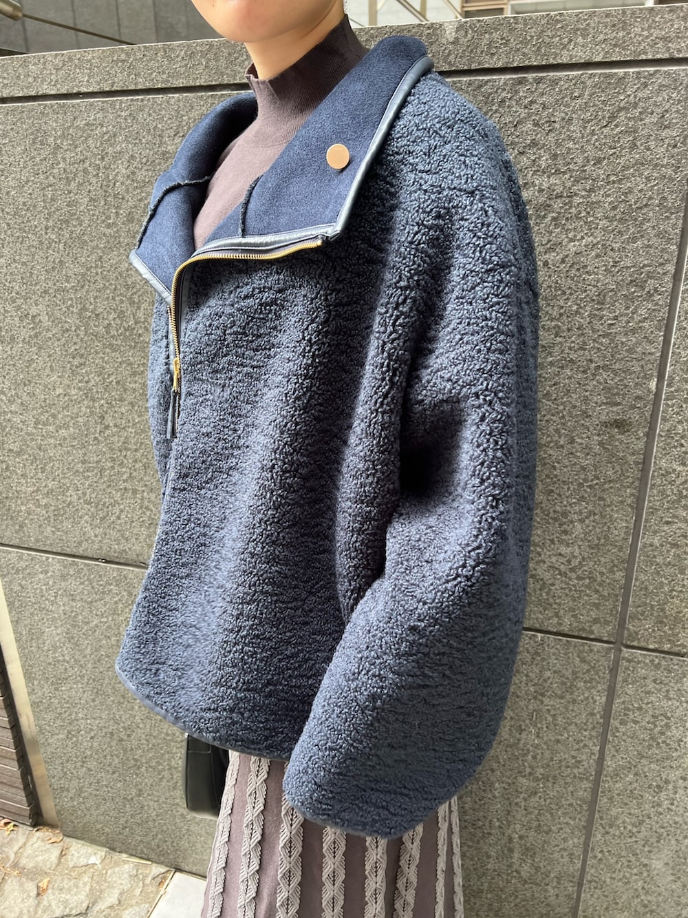 ベージュ系のブーツ、ブラック系のハンドバッグ、ブルー系のムートンコートを着用したレディースの秋コーディネートの5枚目の写真