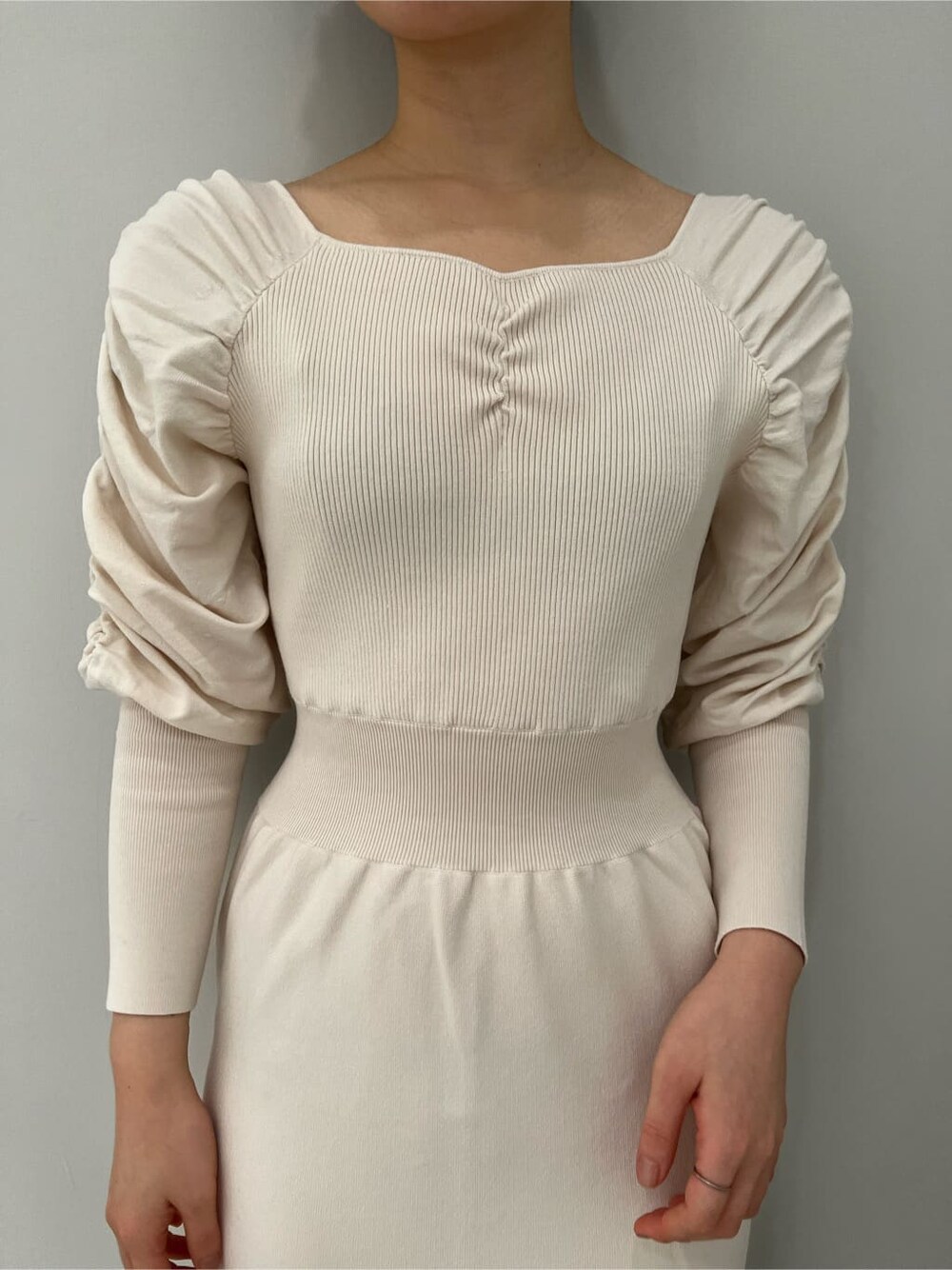 ベージュ系のブーツ、ホワイト系のワンピースを着用したレディースの冬コーディネートの5枚目の写真