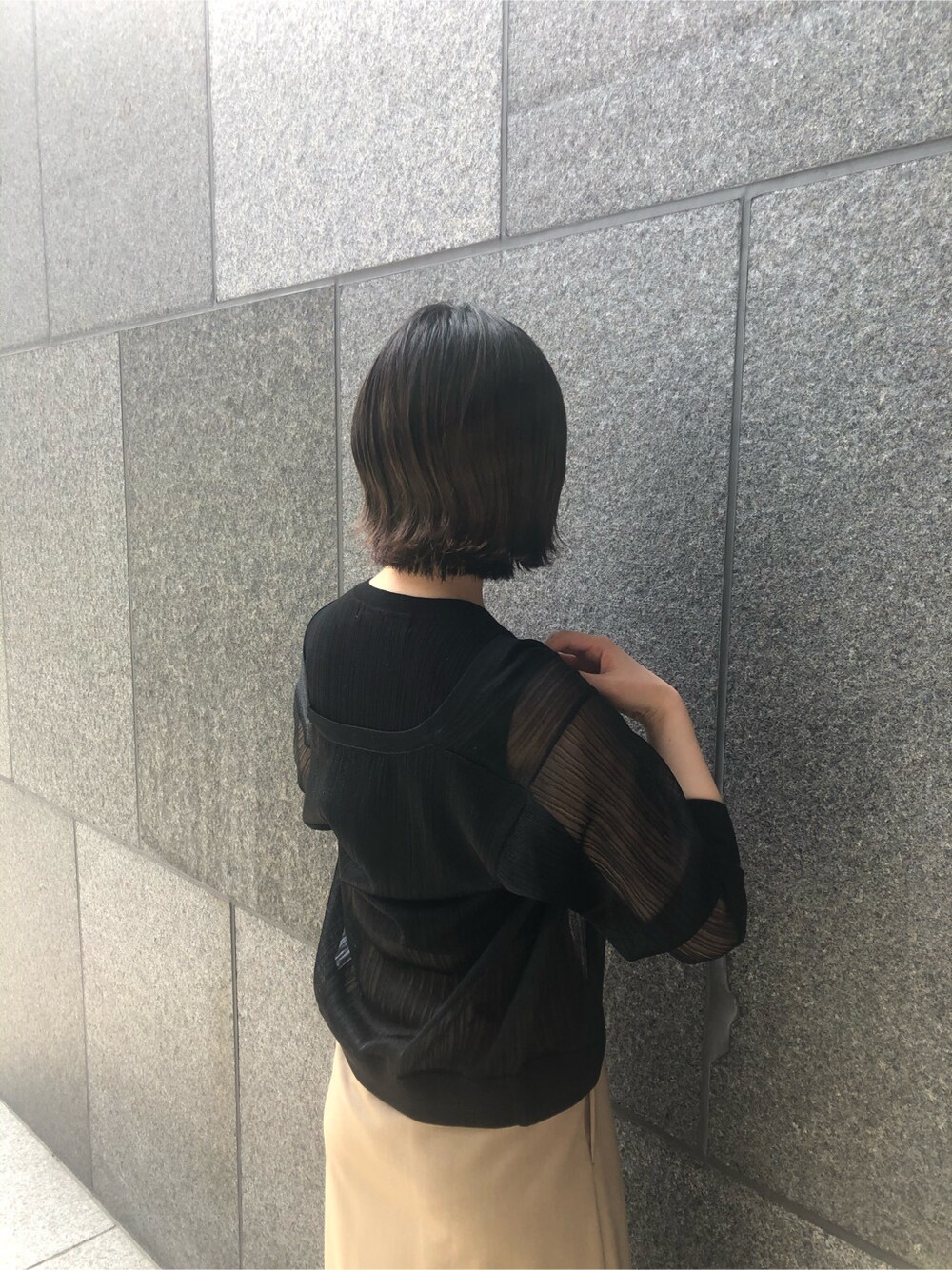 ブラック系のニット/セーター、ブラウン系のパンプス、パープル系のハンドバッグを着用したレディースの春コーディネートの5枚目の写真