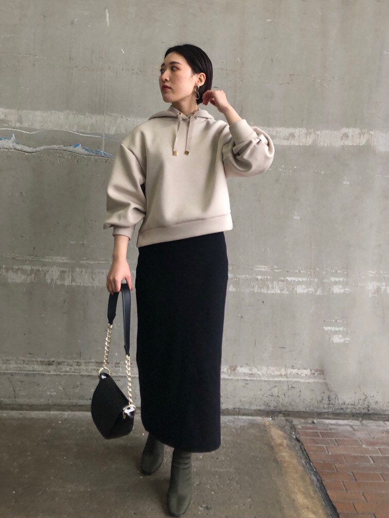 グレー系のパーカー、ブラック系のスカート、グレー系のパーカーを着用したレディースの冬コーディネートの2枚目の写真