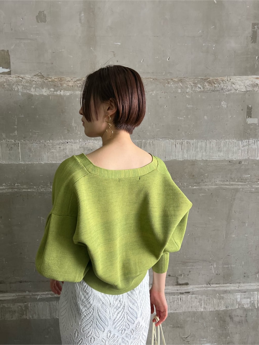 ホワイト系のハンドバッグ、ホワイト系のスカート、ホワイト系のサンダルを着用したレディースの春コーディネートの6枚目の写真