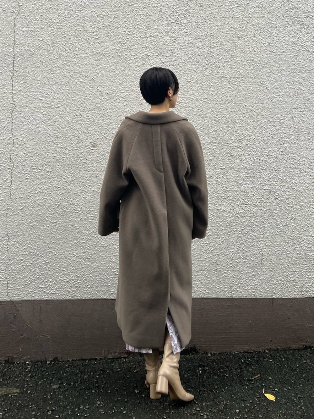 ベージュ系のブーツ、ベージュ系のその他アウター、ホワイト系のニット/セーターを着用したレディースの秋コーディネートの3枚目の写真