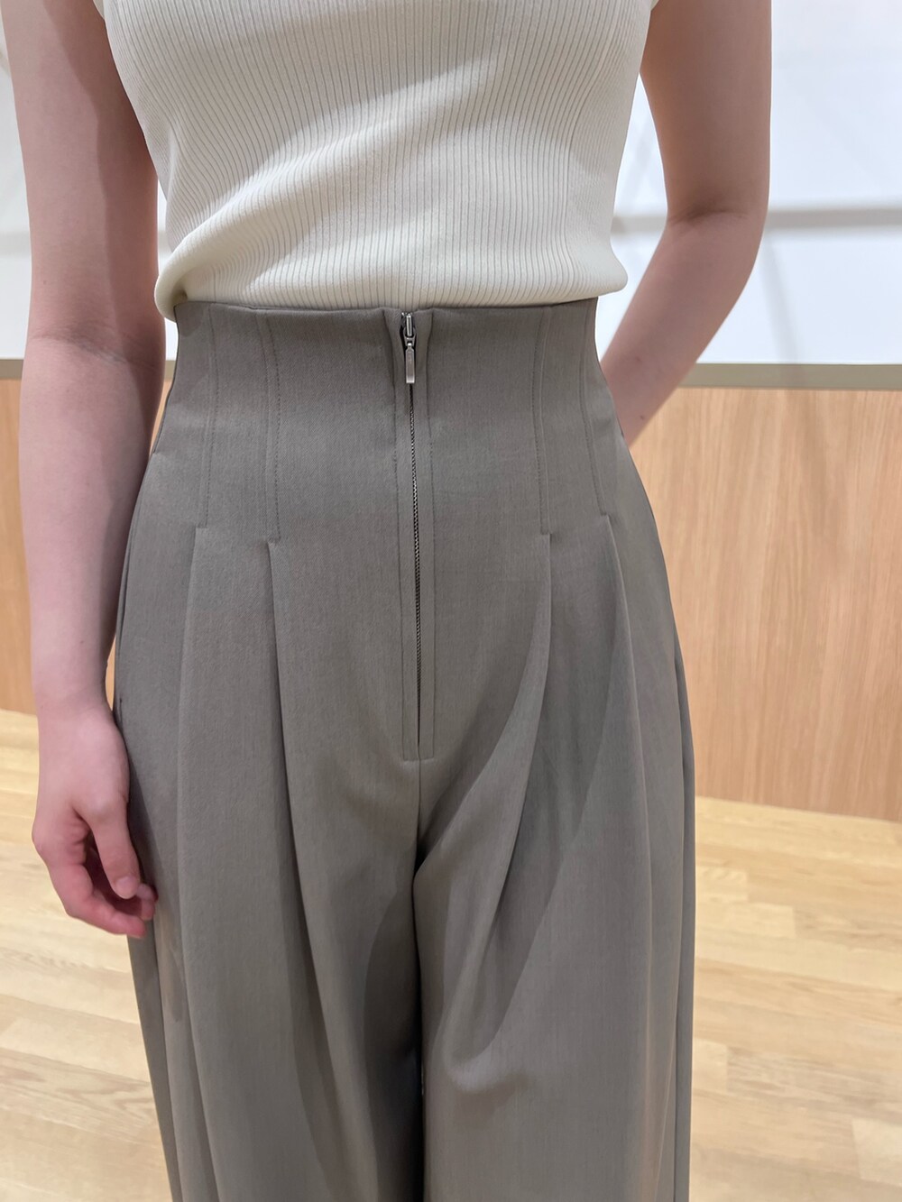 ブラウン系のその他パンツ、ブラック系のサンダル、ホワイト系のニット/セーターを着用したレディースの春コーディネートの5枚目の写真