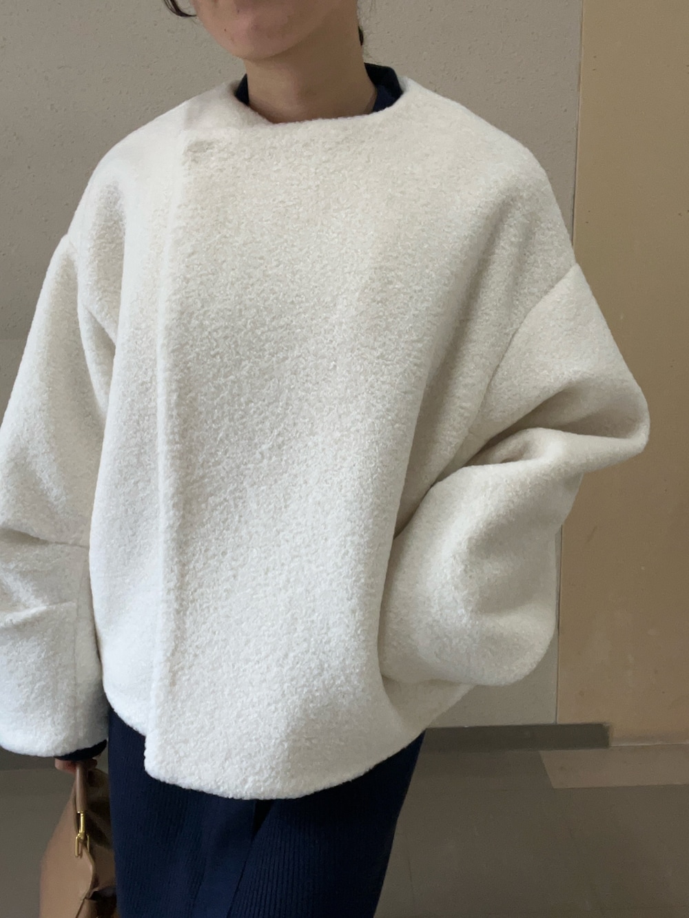 ホワイト系のブルゾン、ブルー系のワンピース、ブラック系のブーツを着用したレディースの秋コーディネートの6枚目の写真