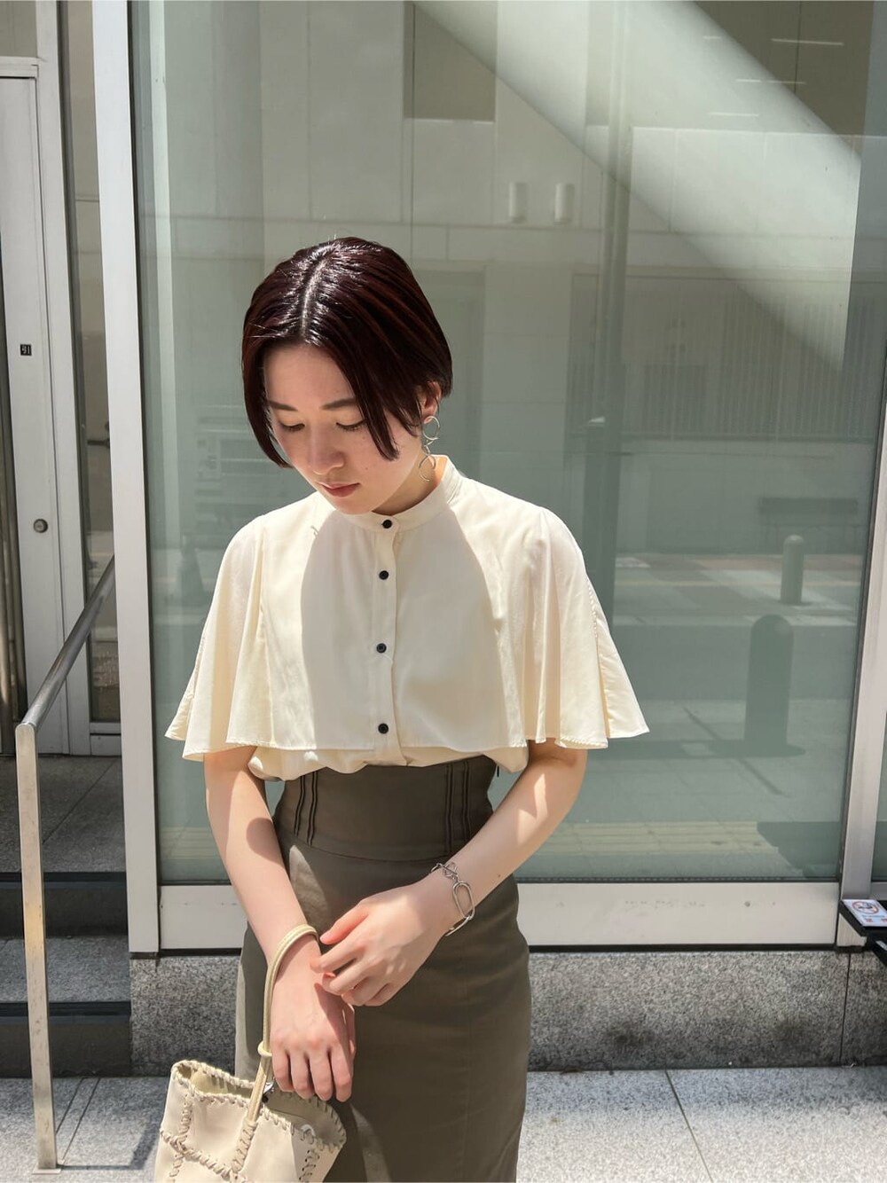 グリーン系のサンダル、ベージュ系のスカート、ホワイト系のショルダーバッグを着用したレディースの夏コーディネートの6枚目の写真