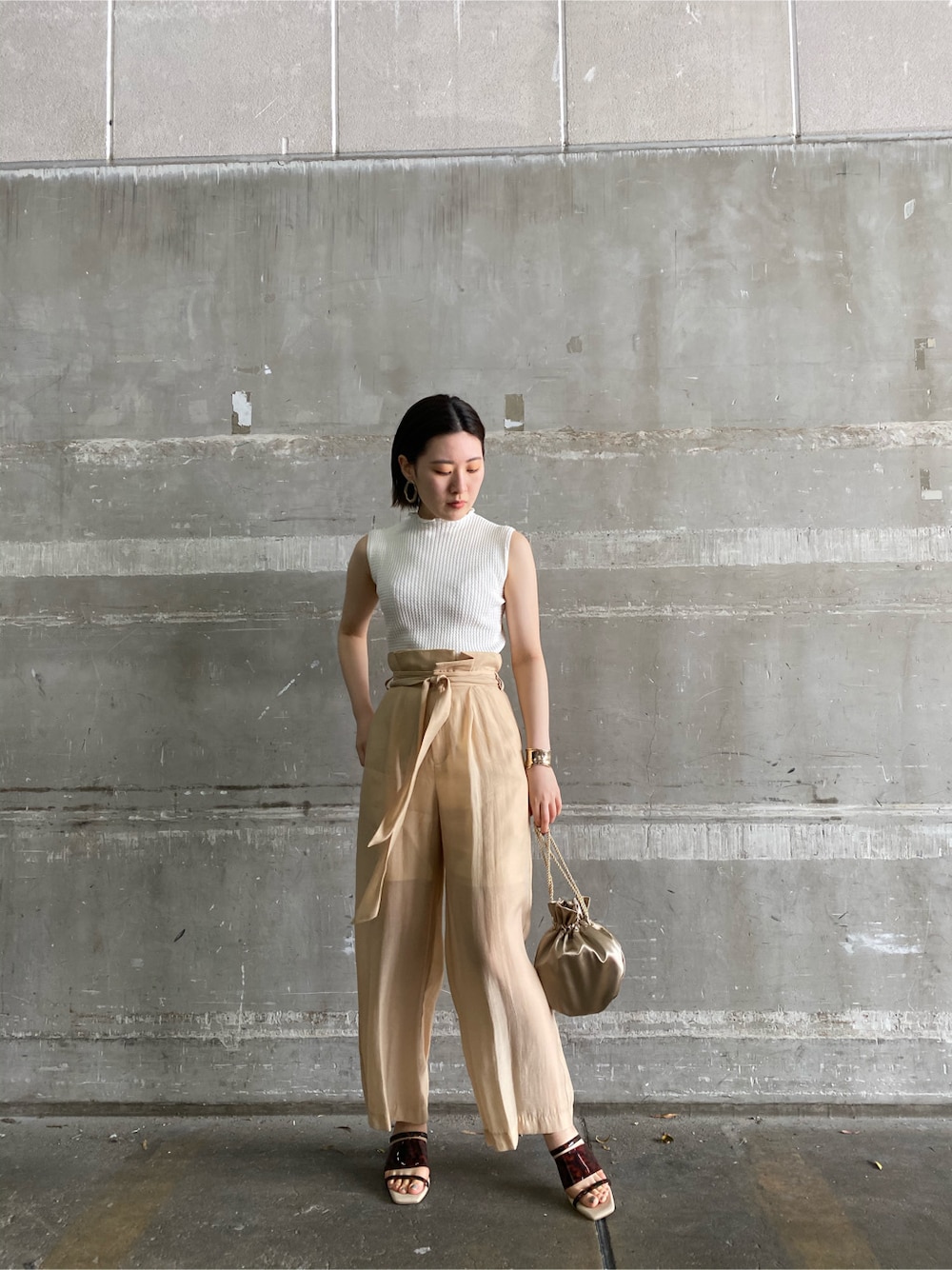 その他のその他シューズ、ベージュ系のその他パンツ、ゴールド系のハンドバッグを着用したレディースの春コーディネートの4枚目の写真