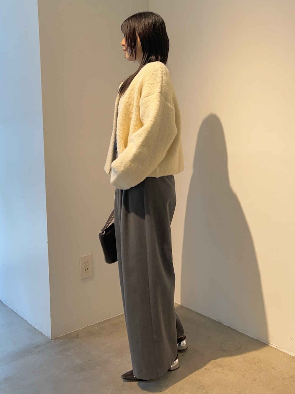 グレー系のその他パンツ、ブラウン系のハンドバッグ、ホワイト系のカーディガン/ボレロを着用したレディースの秋コーディネートの2枚目の写真