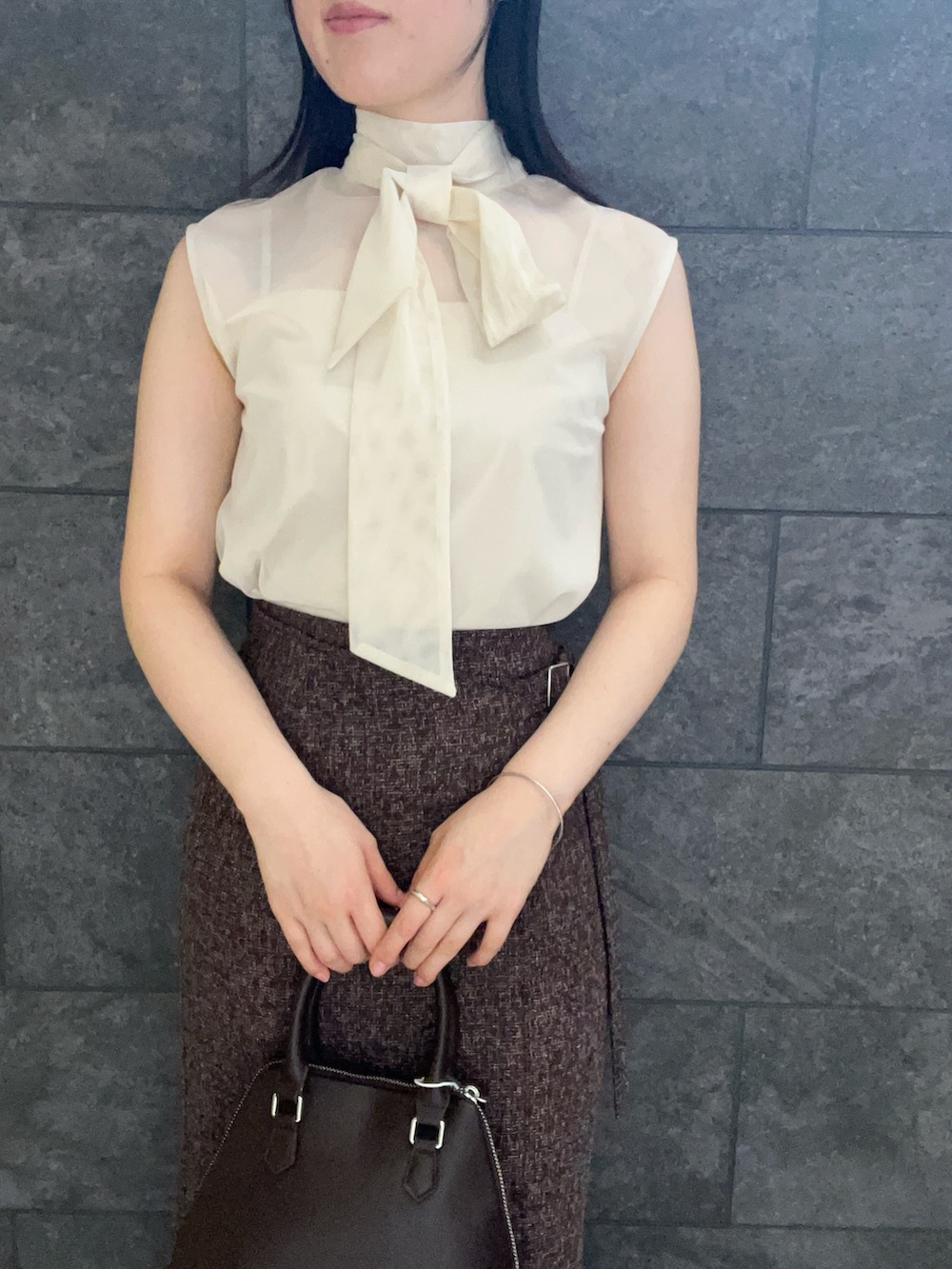 ブラウン系のボストンバッグ、ホワイト系のシャツ/ブラウス、ブラウン系のスカートを着用したレディースの夏コーディネートの4枚目の写真