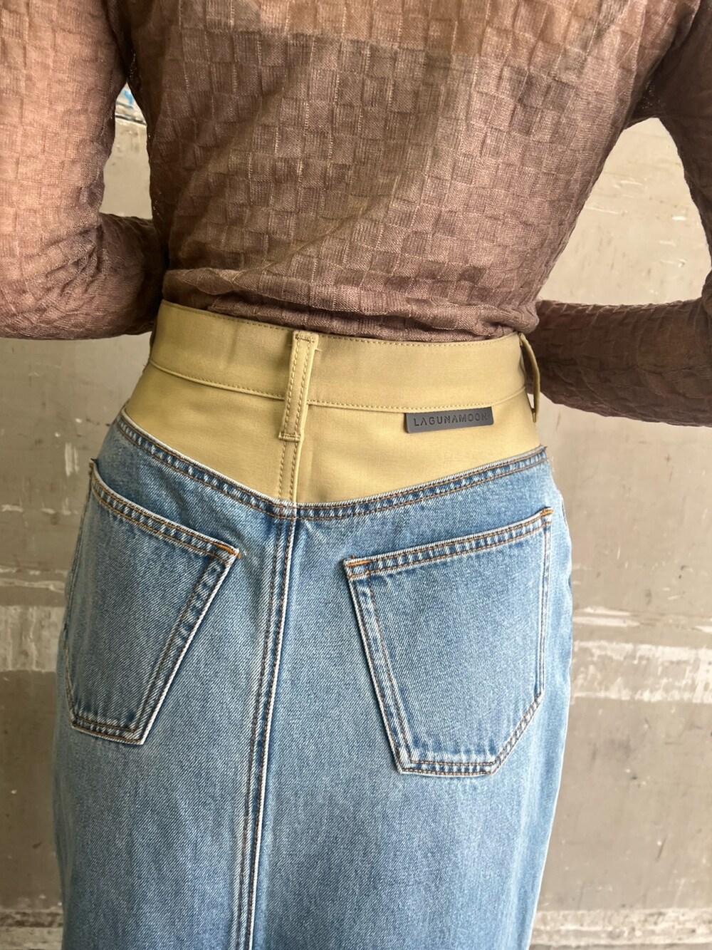 シルバー系のパンプス、グリーン系のテーラードジャケット、グリーン系のデニムスカートを着用したレディースの冬コーディネートの8枚目の写真