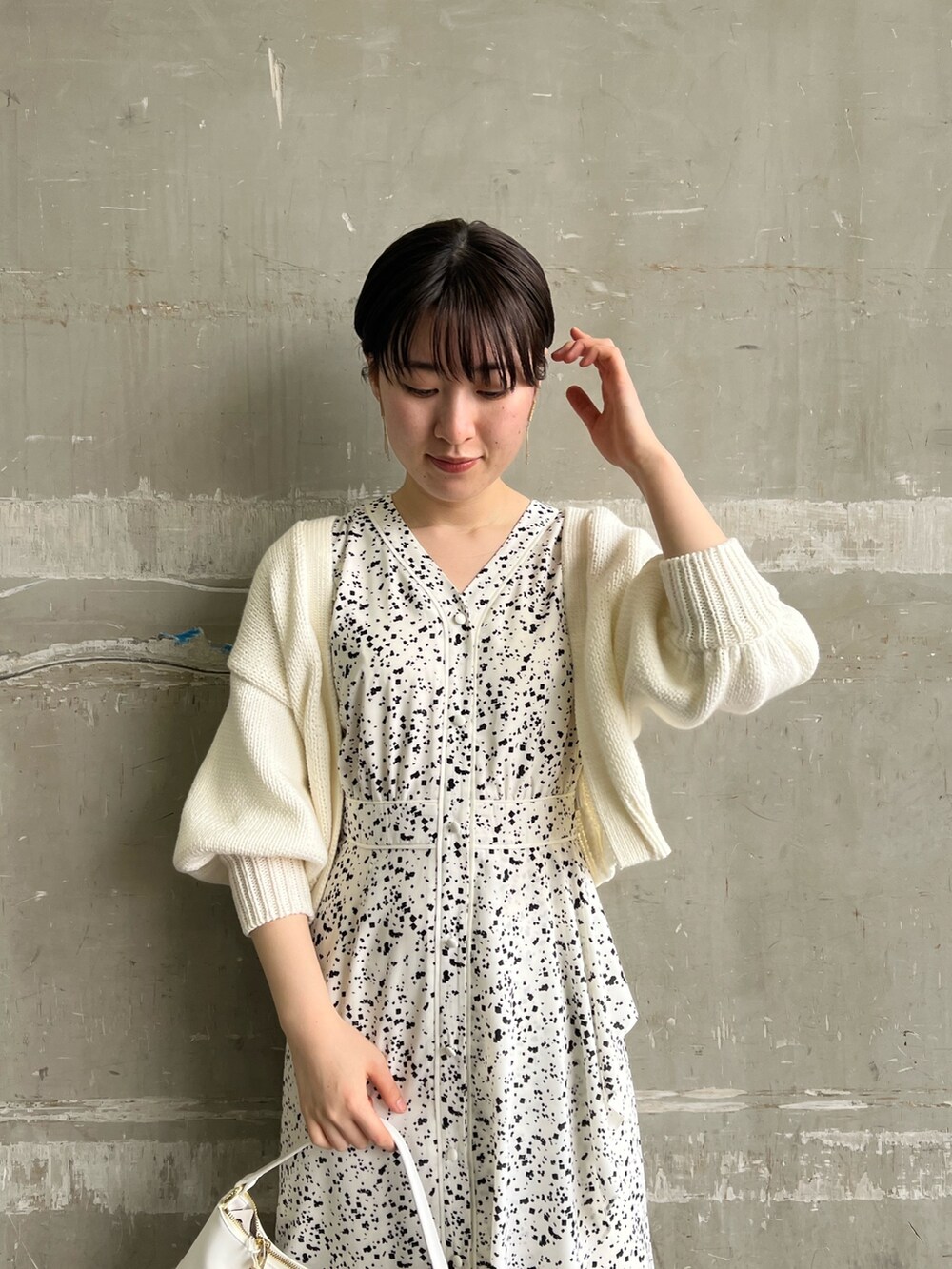 ホワイト系のワンピース、ホワイト系のカーディガン/ボレロ、ベージュ系のサンダルを着用したレディースの春コーディネートの4枚目の写真