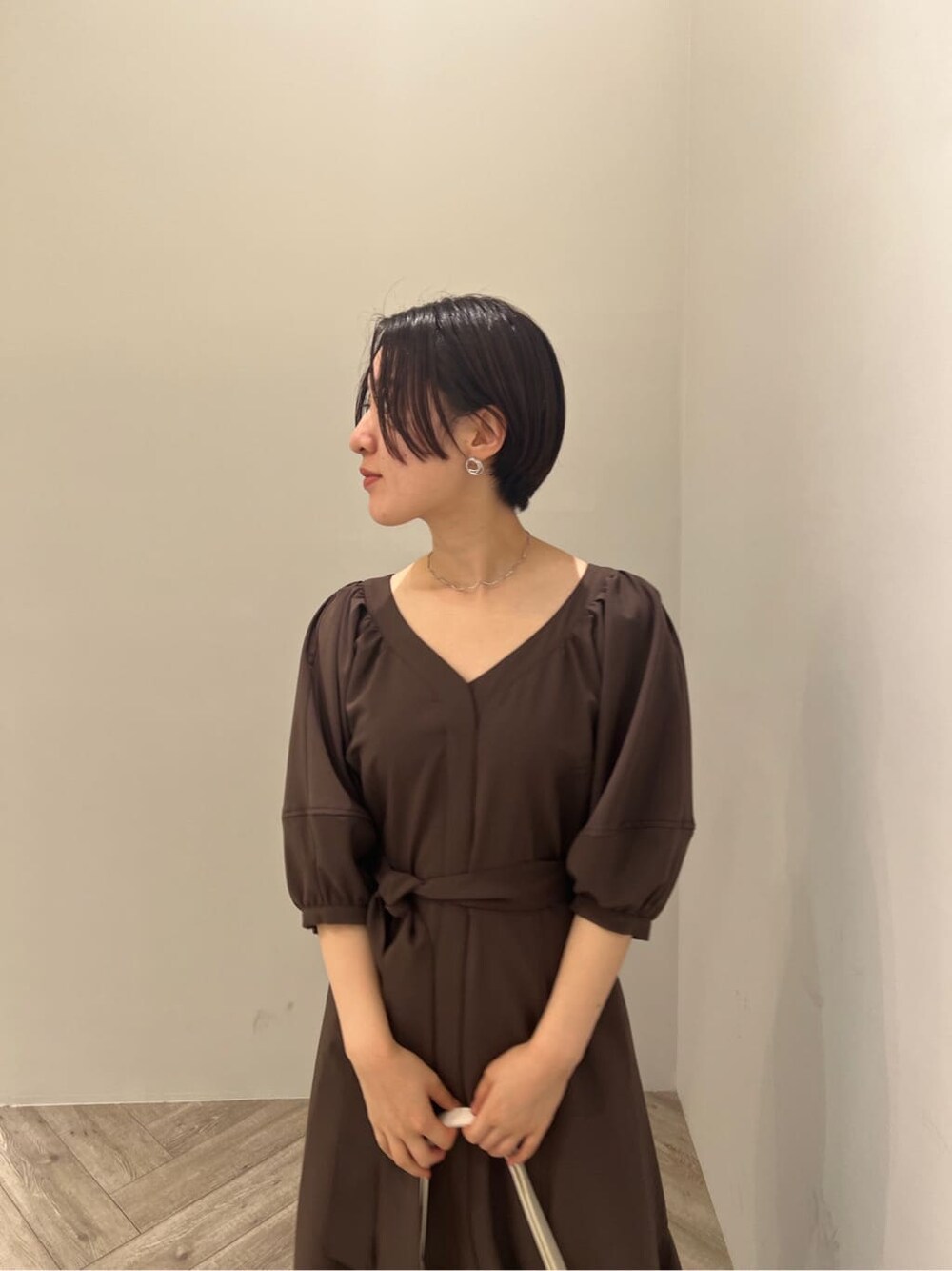 ホワイト系のサンダル、ブラウン系のワンピース、ホワイト系のショルダーバッグを着用したレディースの夏コーディネートの6枚目の写真