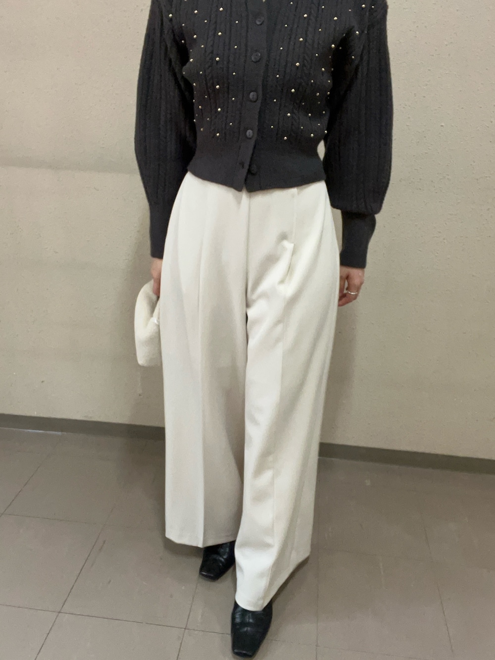 ブラック系のブーツ、グレー系のニット/セーター、ホワイト系のその他パンツを着用したレディースの秋コーディネートの6枚目の写真