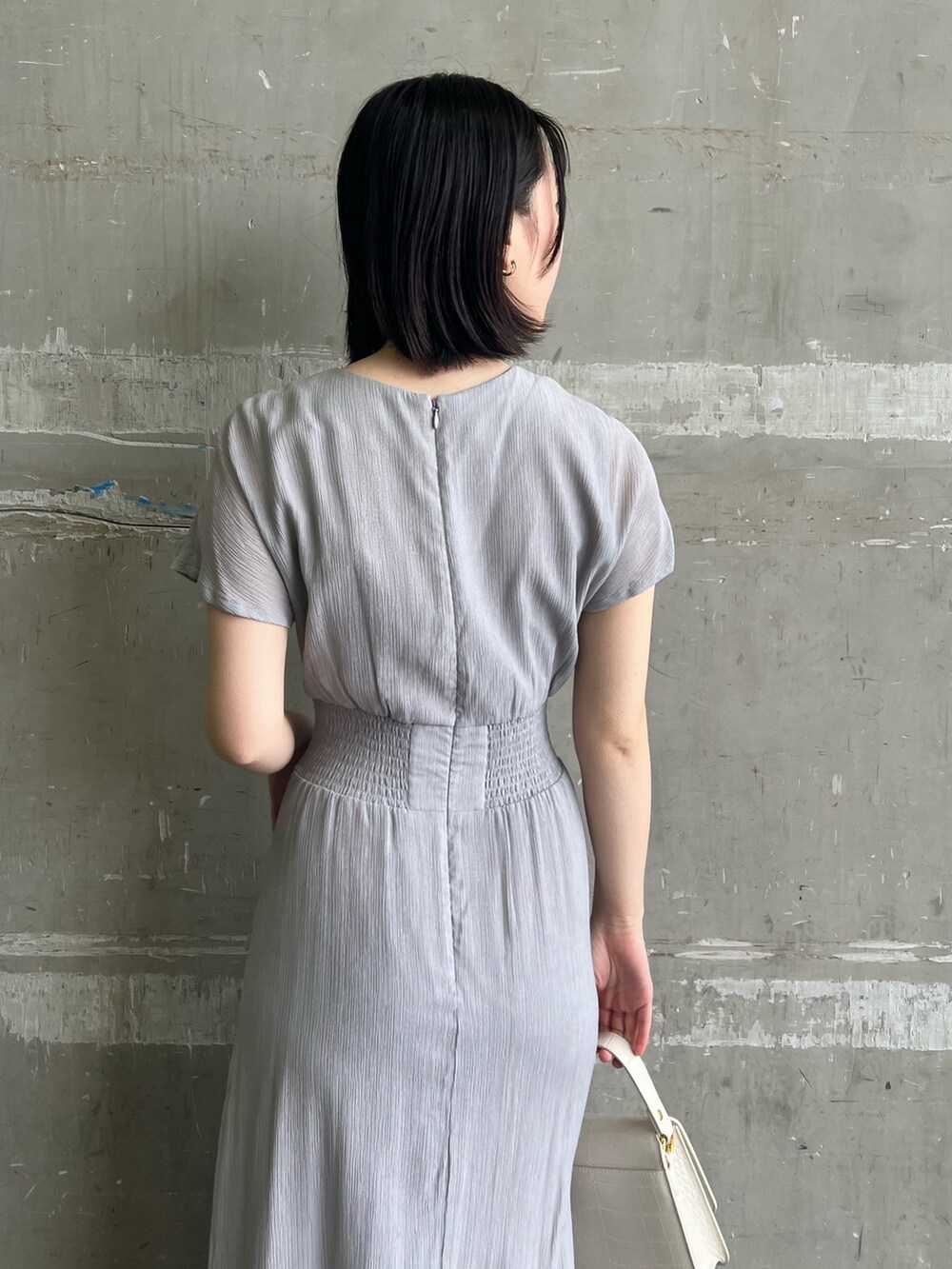 ブラック系のサンダル、ホワイト系のショルダーバッグ、ベージュ系のテーラードジャケットを着用したレディースの春コーディネートの9枚目の写真