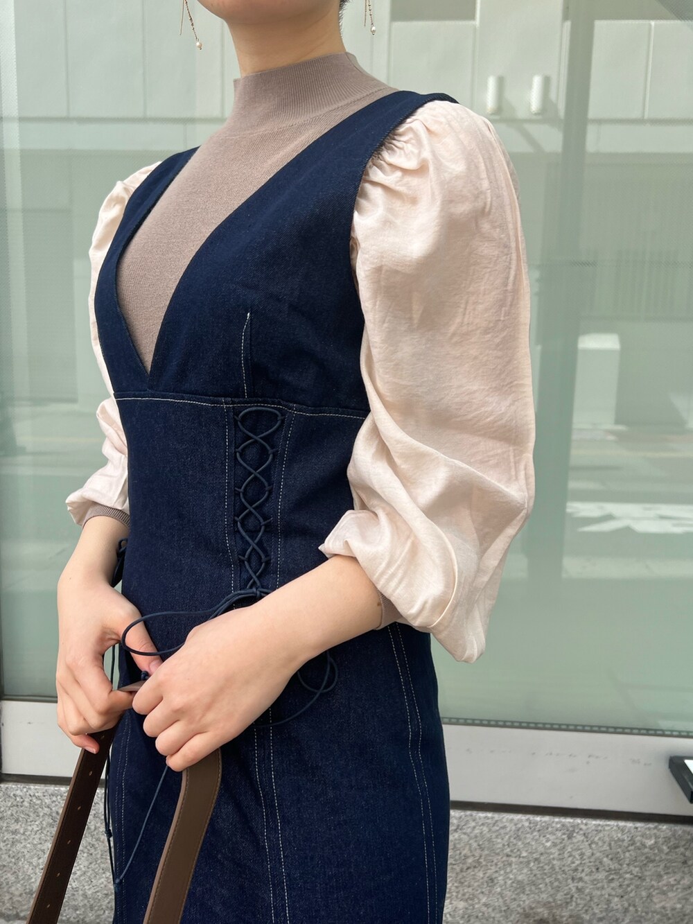 ベージュ系のカーディガン/ボレロ、レッド系のブーツ、ブラウン系のニット/セーターを着用したレディースの冬コーディネートの5枚目の写真