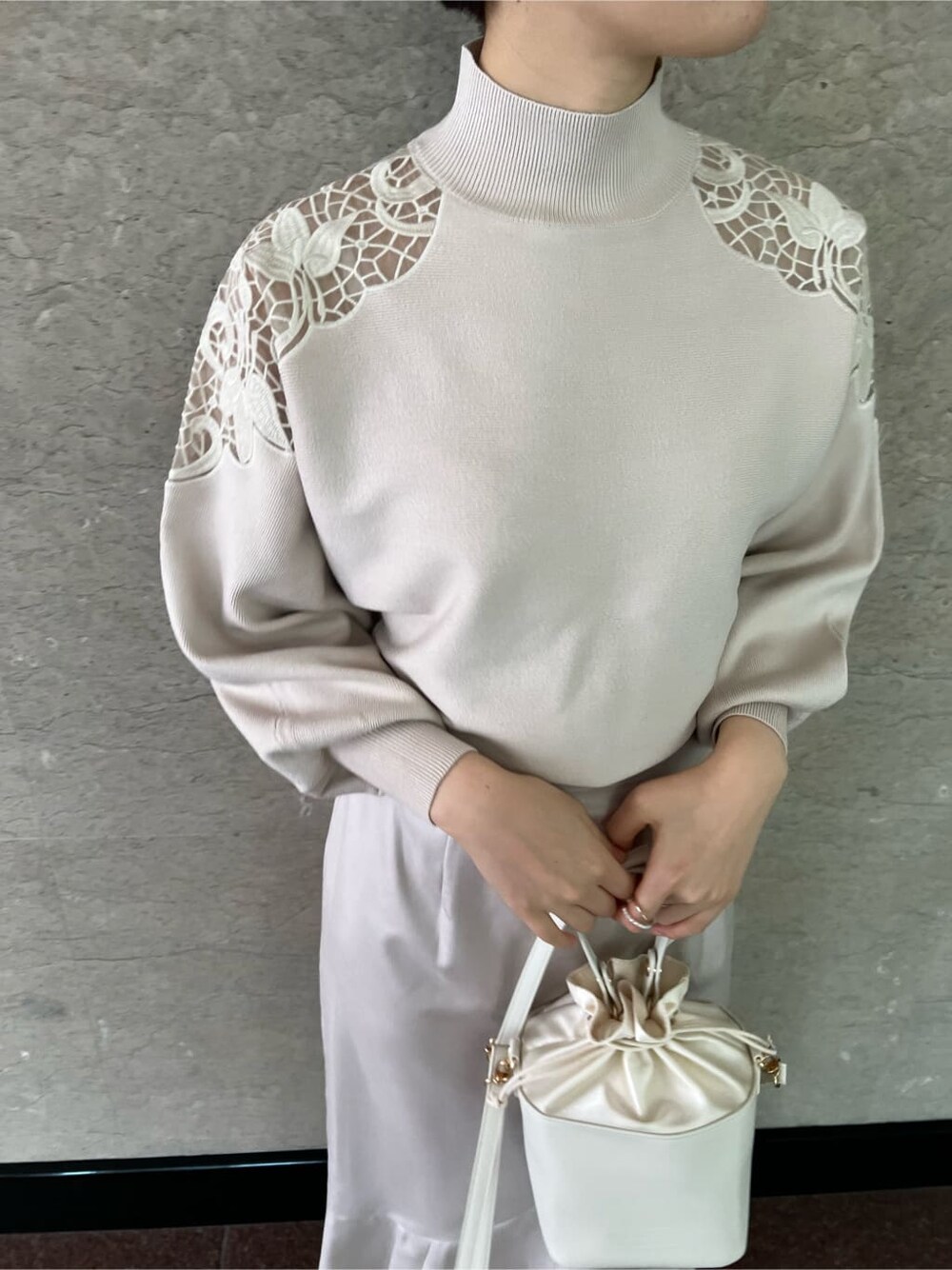 グレー系のスカート、パープル系のその他アウター、ホワイト系のハンドバッグを着用したレディースの冬コーディネートの6枚目の写真