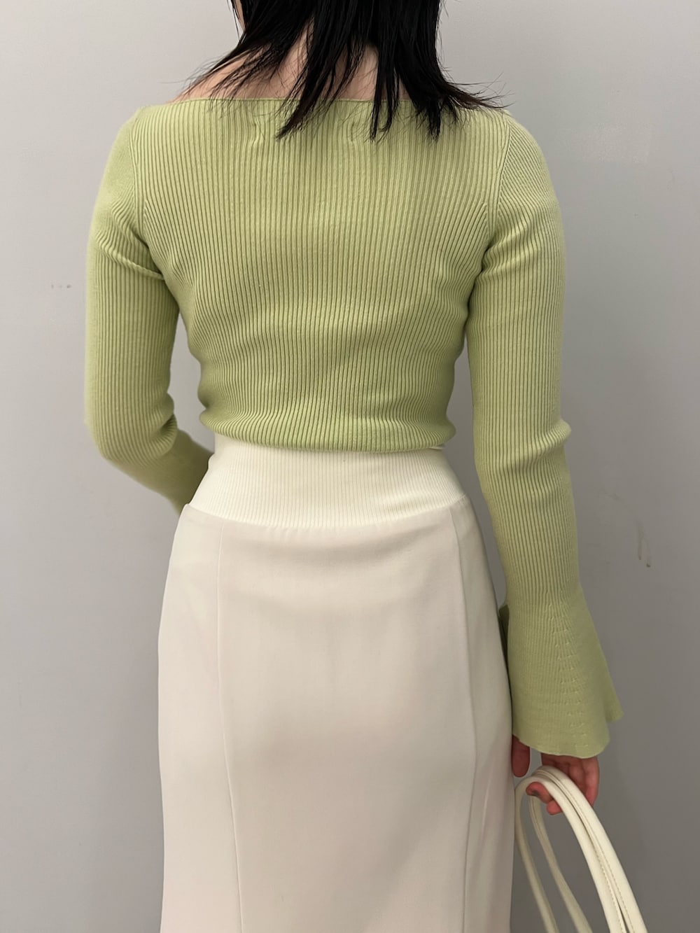 グリーン系のニット/セーター、ホワイト系のスカートを着用したレディースの冬コーディネートの7枚目の写真