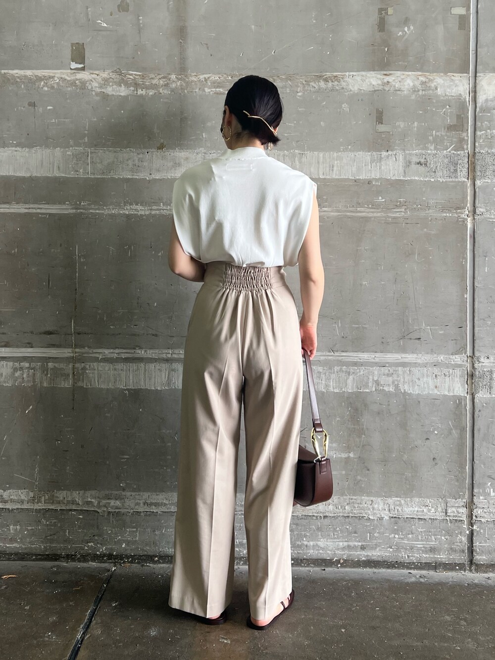 ブラウン系のサンダル、ベージュ系のハンドバッグ、ホワイト系のニット/セーターを着用したレディースの夏コーディネートの3枚目の写真