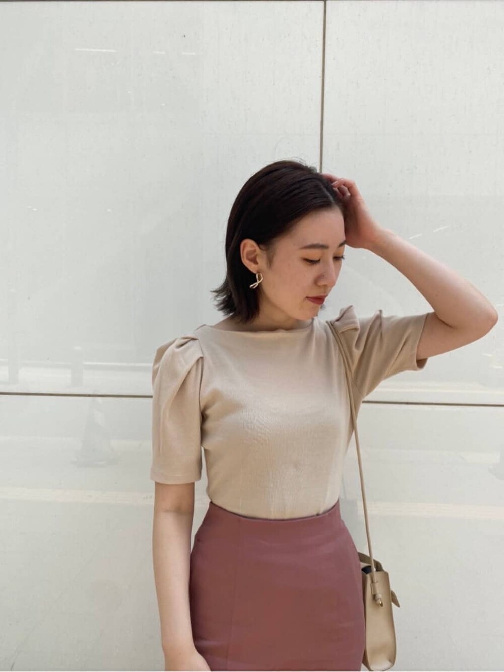 ベージュ系のTシャツ/カットソー、ブラウン系のサンダル、ベージュ系のハンドバッグを着用したレディースの夏コーディネートの5枚目の写真