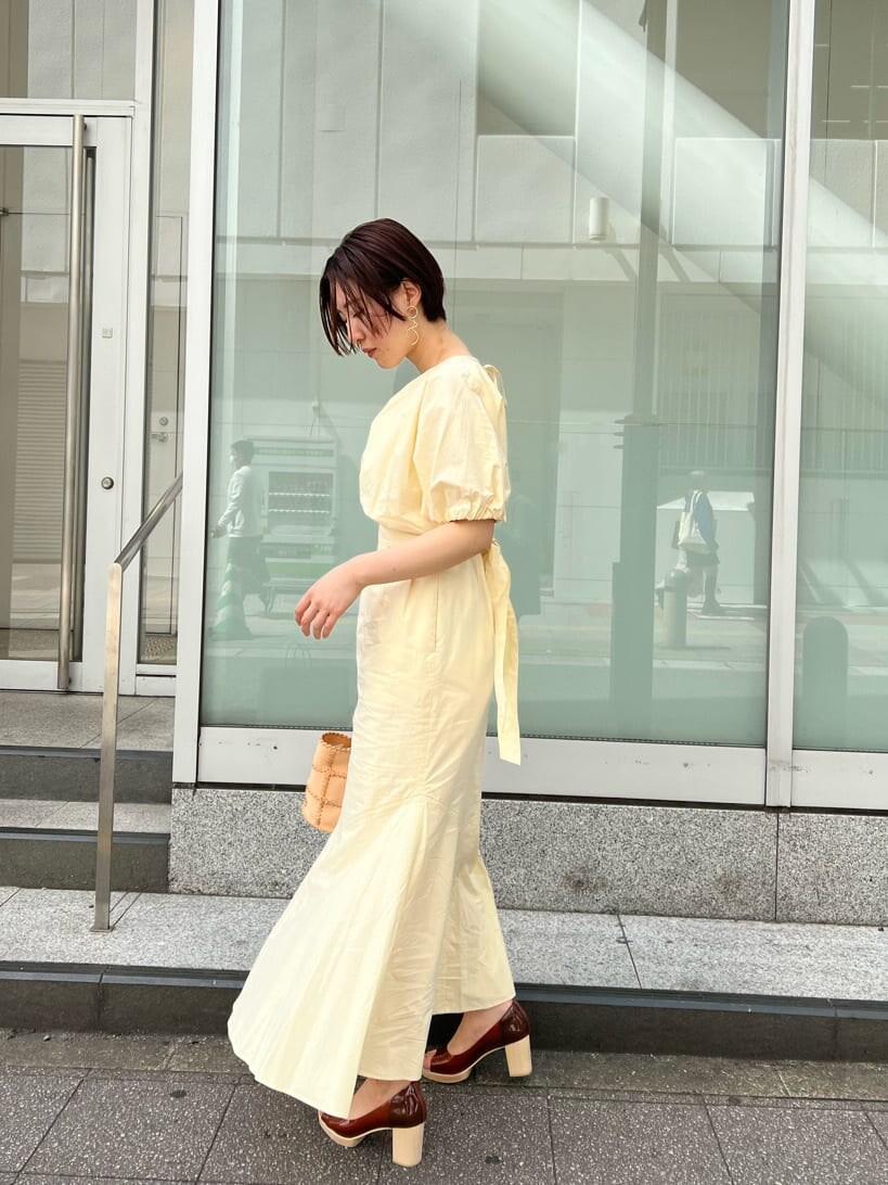 ブルー系のトレンチコート、ブラック系のワンピース、ブラウン系のパンプスを着用したレディースの春コーディネートの7枚目の写真