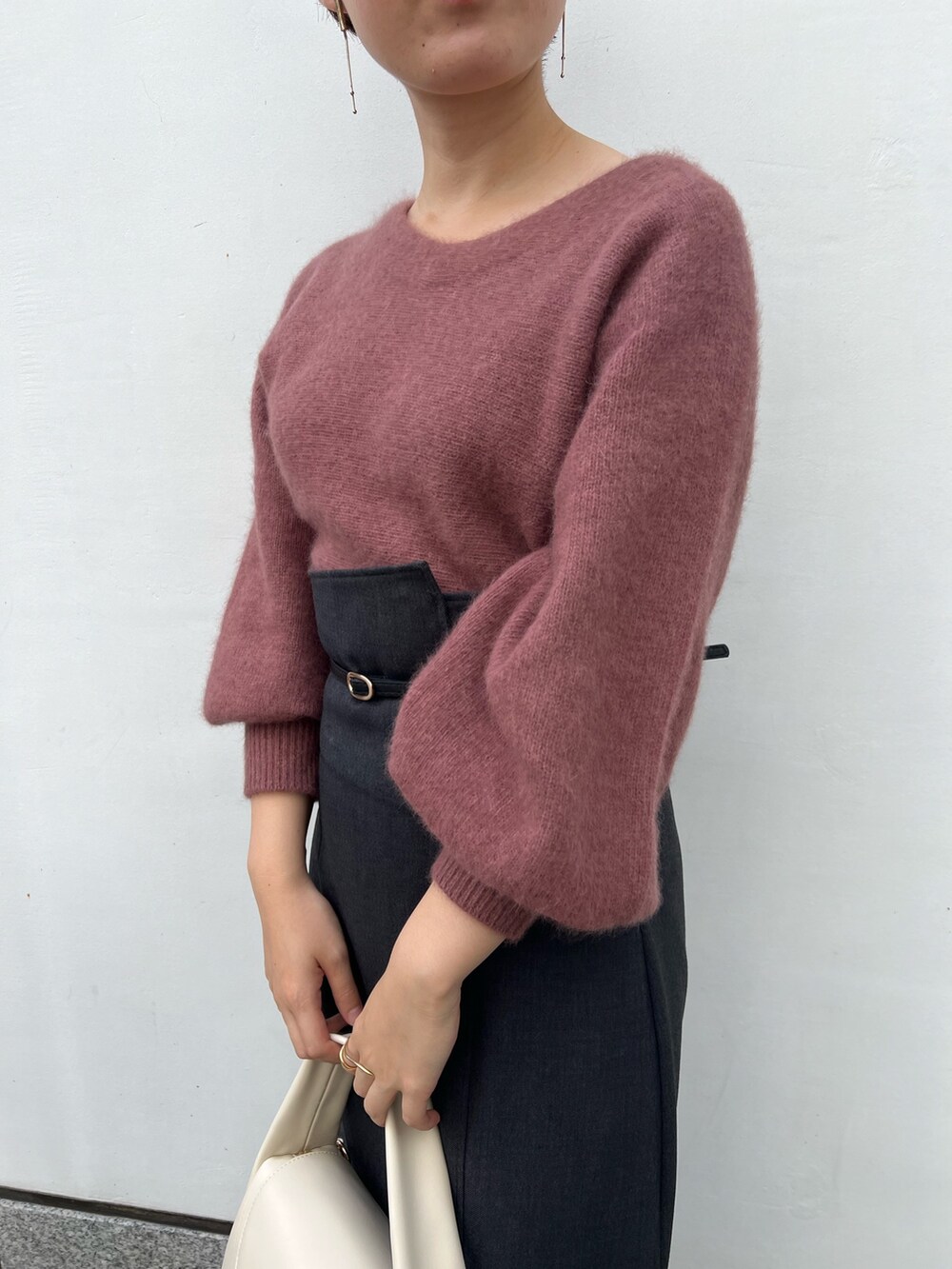 ホワイト系のハンドバッグ、グレー系のスカート、ベージュ系のブーツを着用したレディースの秋コーディネートの7枚目の写真