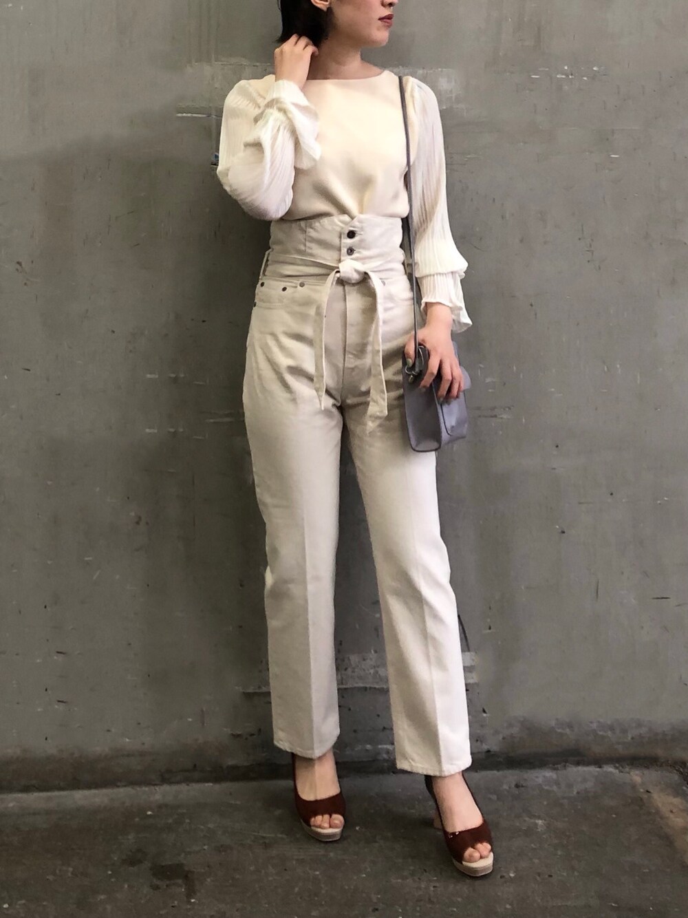 ブラウン系のパンプス、パープル系のハンドバッグ、ホワイト系のニット/セーターを着用したレディースの冬コーディネートの2枚目の写真