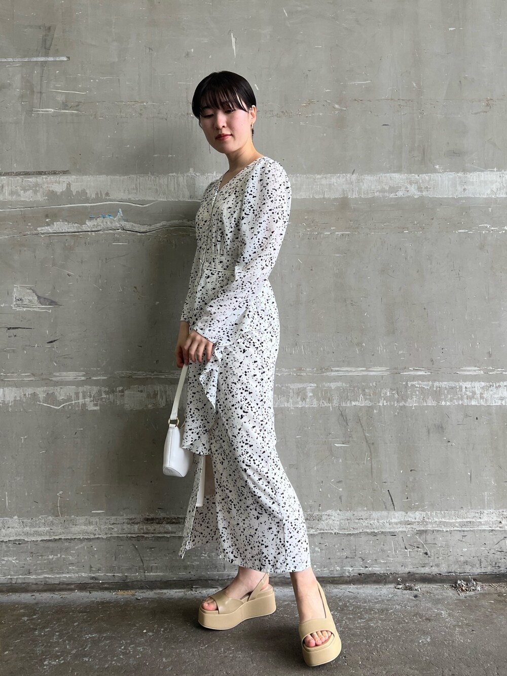 ホワイト系のワンピース、ホワイト系のカーディガン/ボレロ、ベージュ系のサンダルを着用したレディースの春コーディネートの6枚目の写真