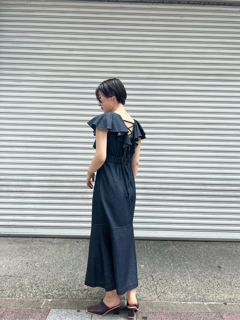 ベージュ系のハンドバッグ、レッド系のサンダル、ブラック系のワンピースを着用したレディースの夏コーディネートの2枚目の写真