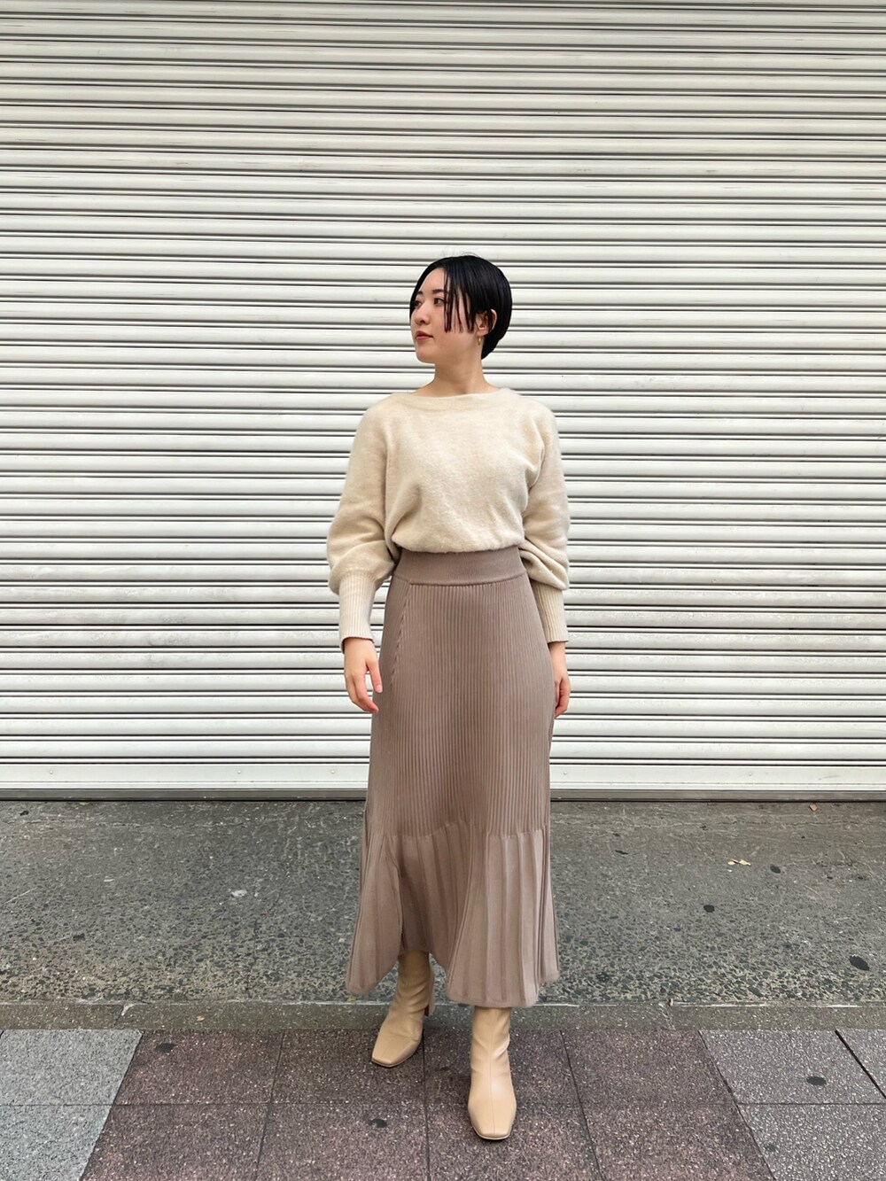 ピンク系のノーカラーコート、ホワイト系のワンピース、ベージュ系のブーツを着用したレディースの秋コーディネートの4枚目の写真