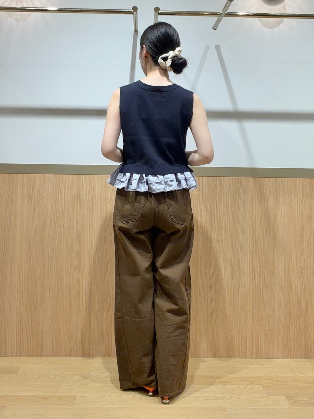 ブルー系のニット/セーター、ブラウン系のデニムパンツ、オレンジ系のサンダルを着用したレディースの夏コーディネートの3枚目の写真