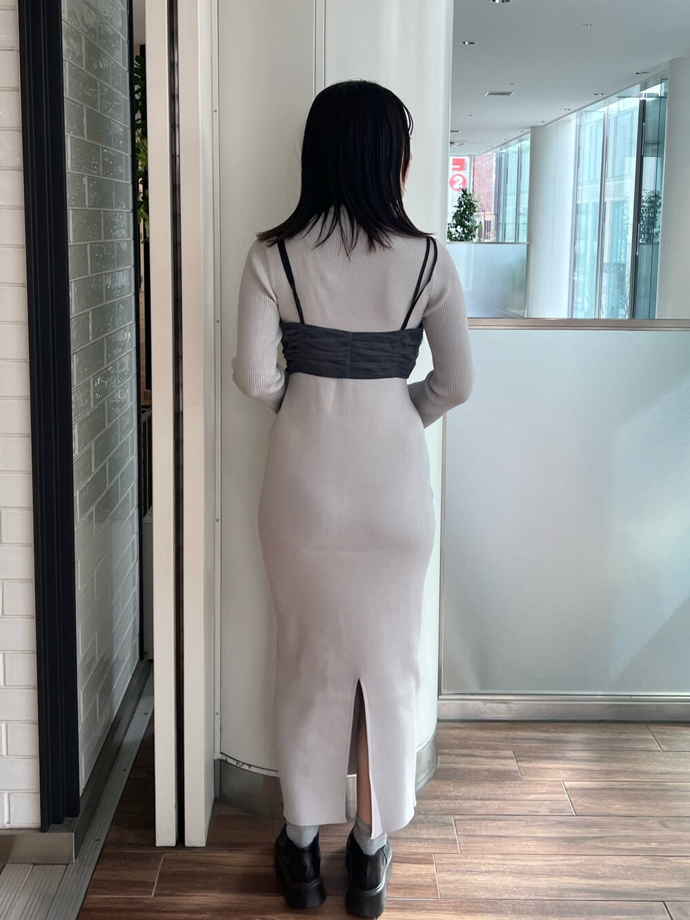 ブラック系のステンカラーコート、ブルー系のワンピース、ブラック系のブーツを着用したレディースの冬コーディネートの10枚目の写真