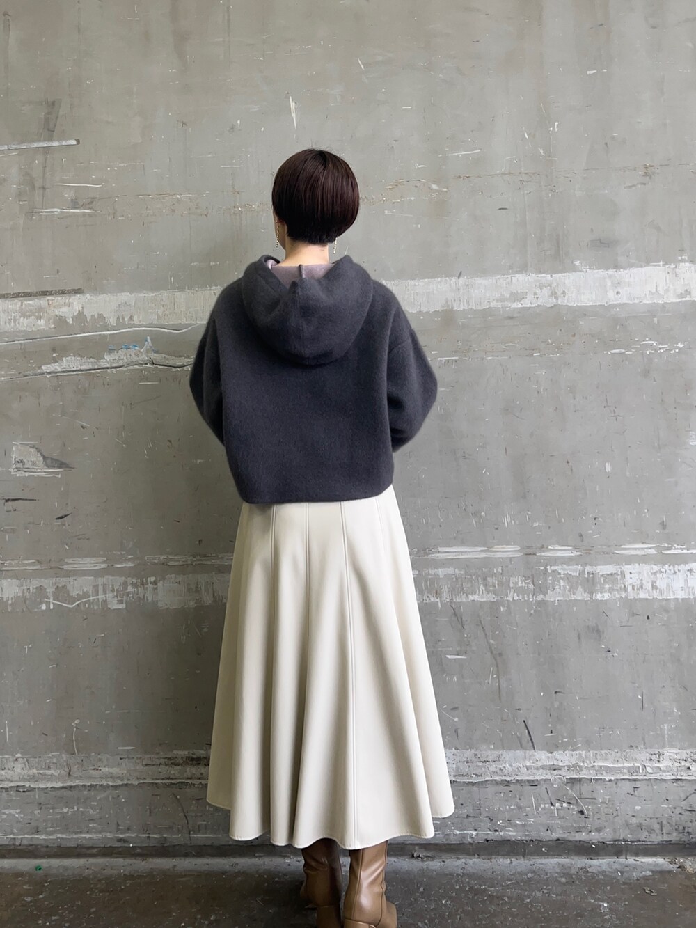 ベージュ系のブーツ、グレー系のパーカー、ホワイト系のスカートを着用したレディースの秋コーディネートの3枚目の写真