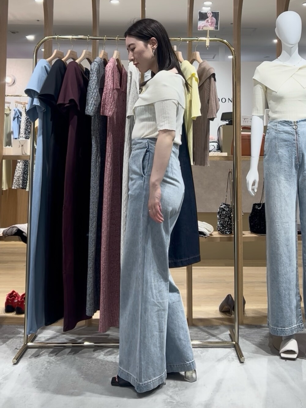 ホワイト系のニット/セーター、ブルー系のデニムパンツ、ブラック系のサンダルを着用したレディースの春コーディネートの2枚目の写真