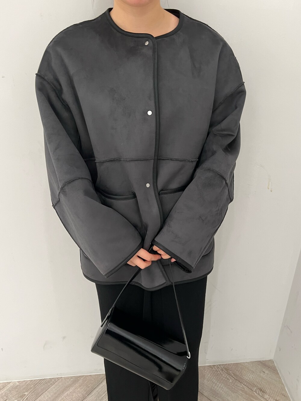 ブラック系のブーツ、グレー系のブルゾン、ホワイト系のTシャツ/カットソーを着用したレディースの秋コーディネートの3枚目の写真