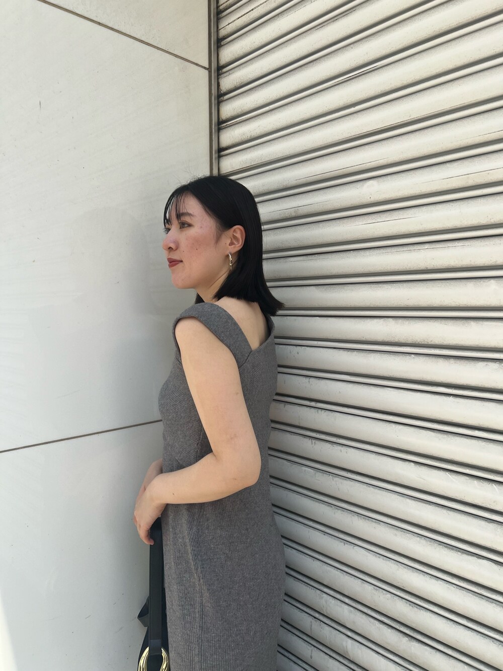 グレー系のワンピース、ブラック系のサンダル、ブラック系のショルダーバッグを着用したレディースの夏コーディネートの5枚目の写真