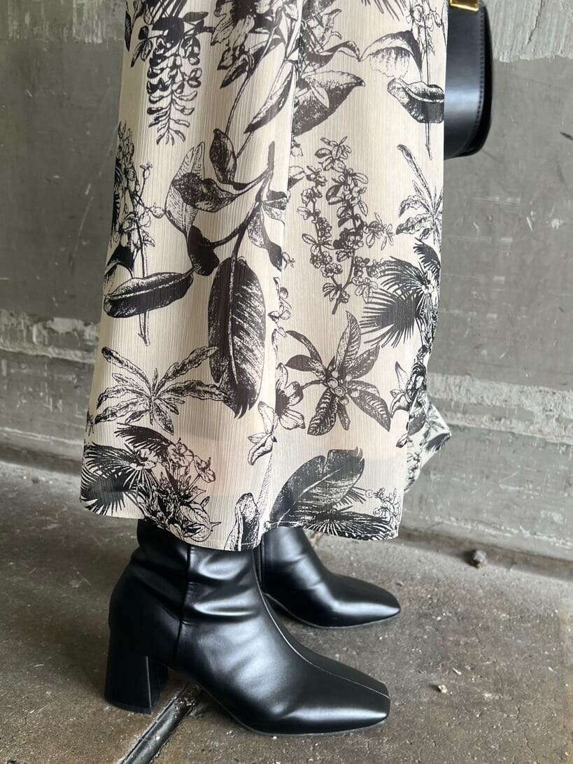 ベージュ系のスカート、ブラック系のブーツ、パープル系のニット/セーターを着用したレディースの秋コーディネートの8枚目の写真